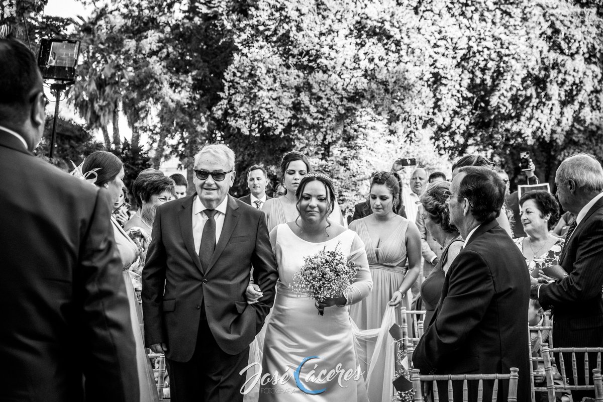 Novia caminando acompañada por el padrino durante la entrada a la ceremonia