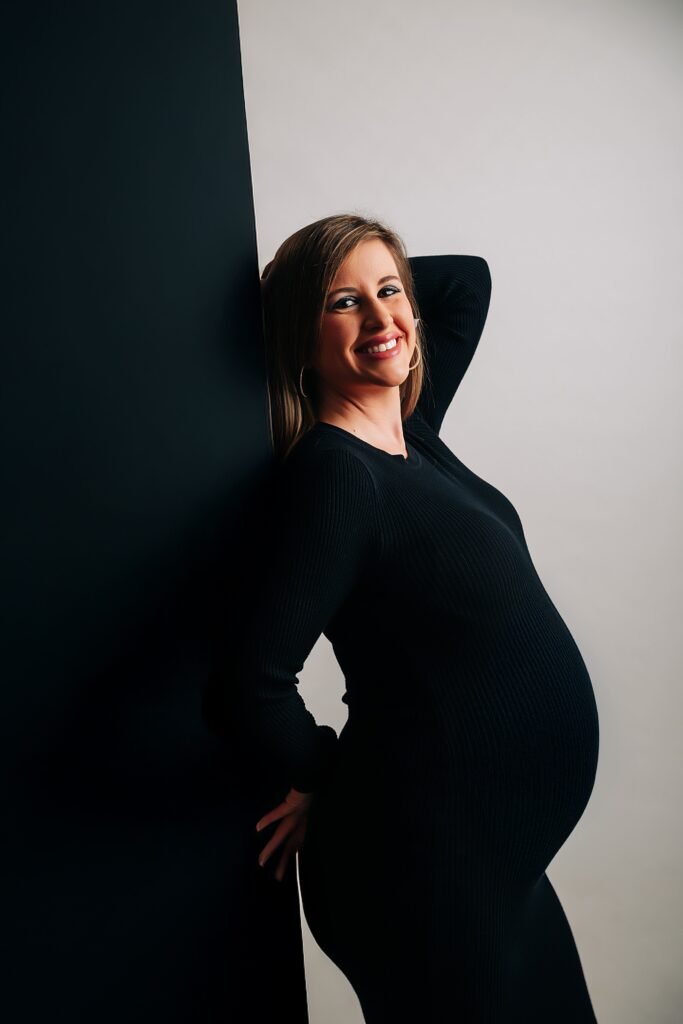 Fotografía de embarazo en Jerez, mujer embarazada en estudio elegante con contraste blanco y negro