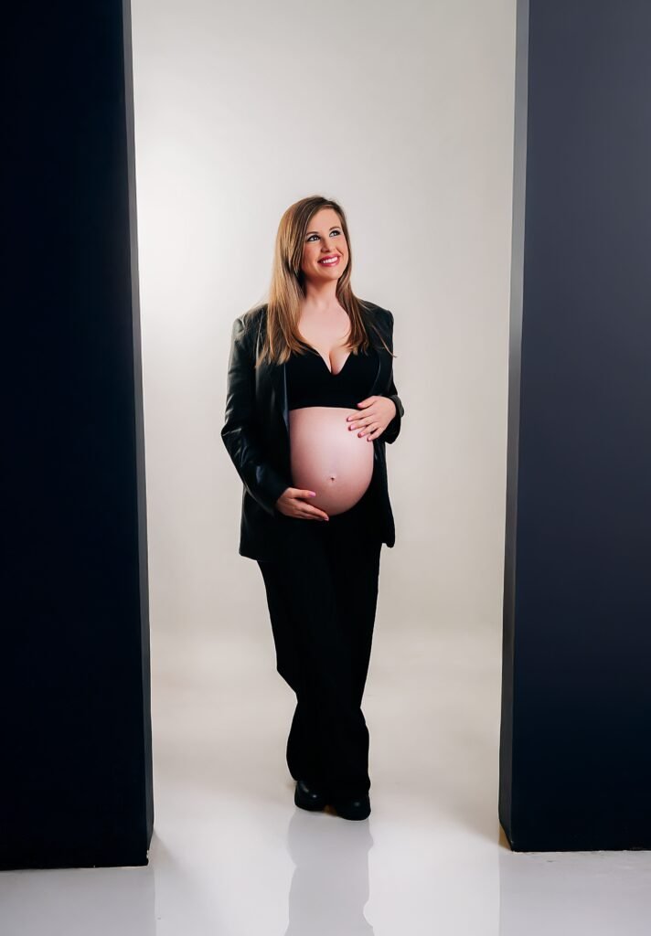 Sesión premamá en Jerez, fotografía artística con fondo blanco y negro mostrando la barriga de embarazo