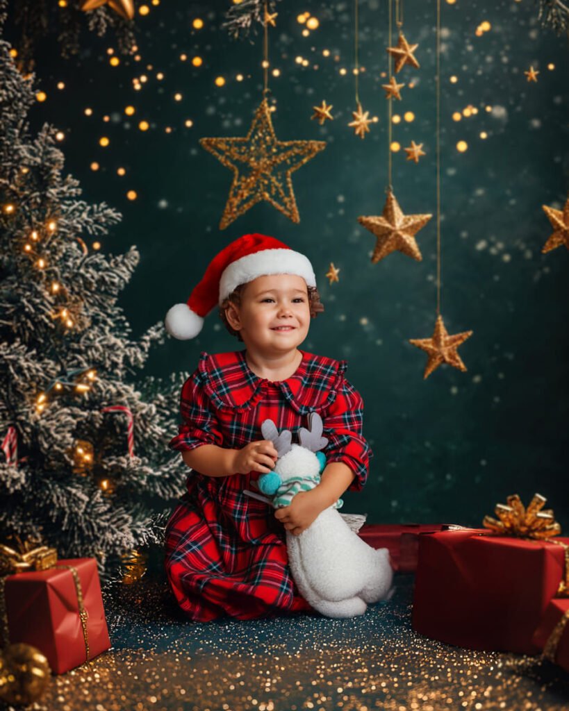 Fotografía navideña 2025 en Estudio José Cáceres, niña con gorro rojo junto al árbol de Navidad. 