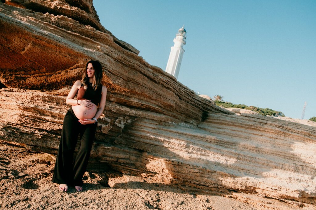 Pareja esperando un bebé paseando por la orilla de la playa de Barbate en invierno.