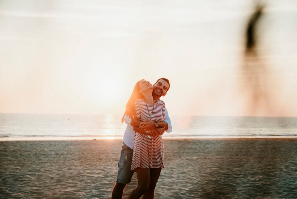 Pareja relajada sentada en la arena tras su reportaje de preboda.