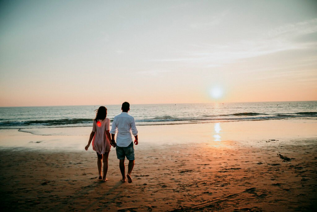 Pareja relajada sentada en la arena tras su reportaje de preboda.
