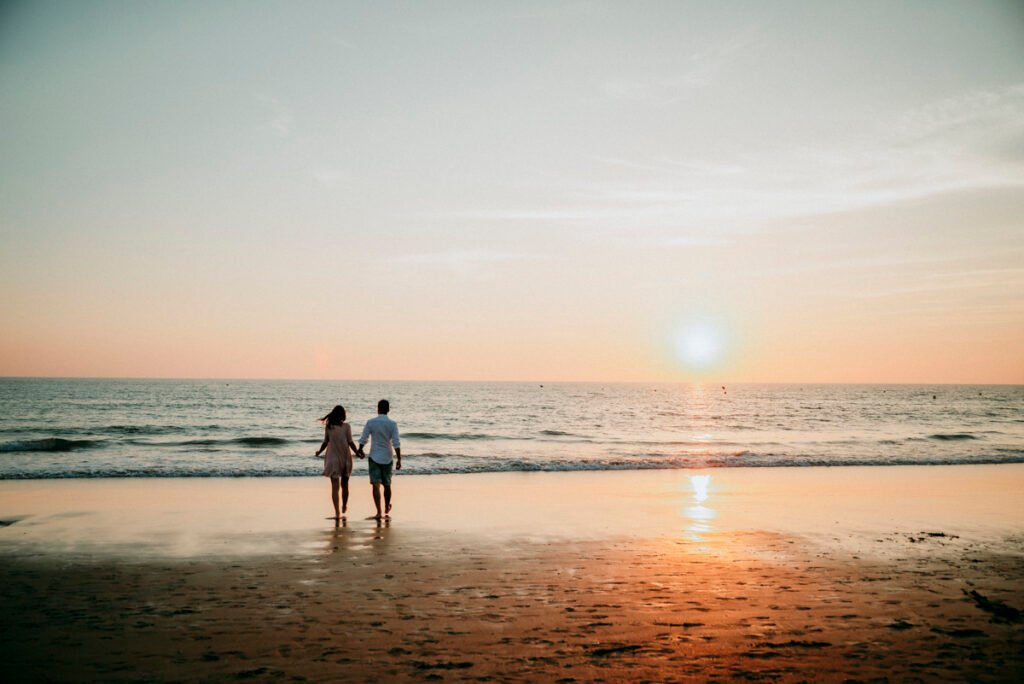 Pareja relajada sentada en la arena tras su reportaje de preboda.