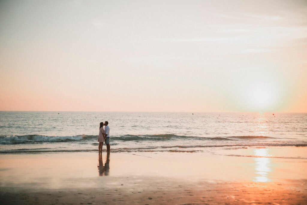 Pareja relajada sentada en la arena tras su reportaje de preboda.