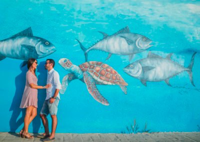 Fotografía de pareja con luz natural entre barcos de pescadores en Cádiz.