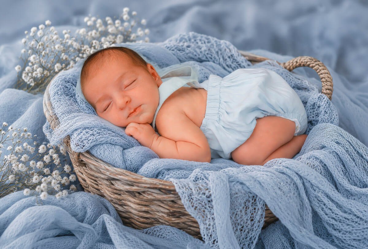 Sesión de fotos newborn en estudio con cesta y escenario preparado